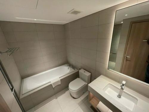 a bathroom with a tub and a toilet and a sink at Căn hộ 2PN view biển Alacarte Hạ Long, bể bơi vô cực in Ha Long