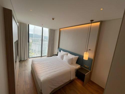 a hotel room with a bed and a large window at Căn hộ 2PN view biển Alacarte Hạ Long, bể bơi vô cực in Ha Long
