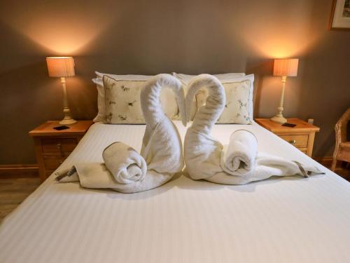 two swans made out of towels on a bed at Abbots Reading Mews 2 in Lake Side