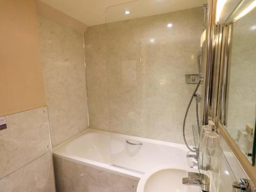 a bathroom with a tub and a toilet and a sink at Abbots Reading Mews 2 in Lake Side