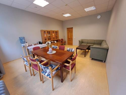 a dining room with a table and chairs and a couch at Atpūtas komplekss Cerības 
