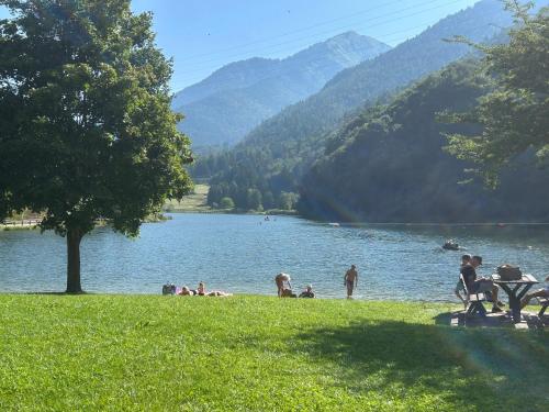 a group of people sitting on the grass near a lake at Casa Willigio in Roncone