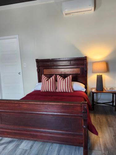 een slaapkamer met een groot houten bed met 2 kussens bij Modern apartment overlooking a Historic Downtown in Elloree