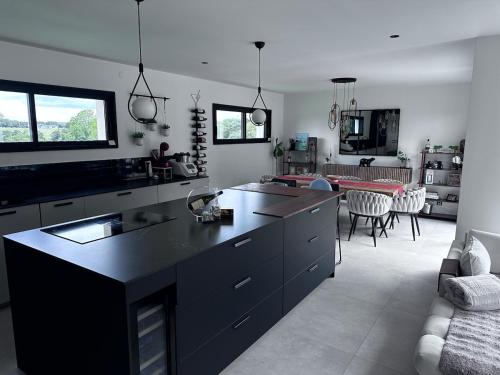 Moustoir-AcにあるModern Britain homeのキッチン(黒いカウンタートップ付)、リビングルーム