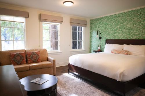 a bedroom with a bed and a couch and a chair at The Stavrand in Guerneville