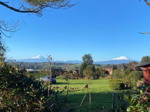 a view of a field with mountains in the background at Lofts Magnolias in Puerto Varas