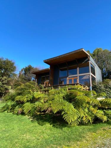 a house on a hill with trees in front of it at Lofts Magnolias in Puerto Varas