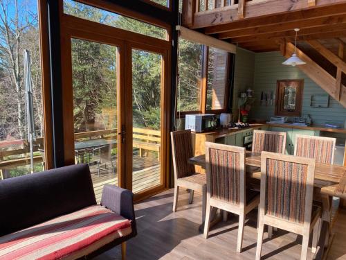 a kitchen and dining room with a table and chairs at Lofts Magnolias in Puerto Varas