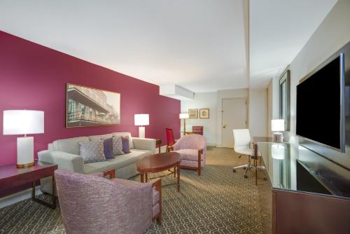 a living room with a couch and a tv at Crowne Plaza New Orleans French Qtr - Astor by IHG in New Orleans