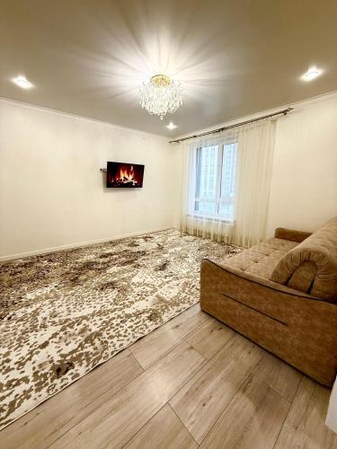 a living room with a couch and a fireplace at Уютные Апартаменты в ЖК Life Park in Astana