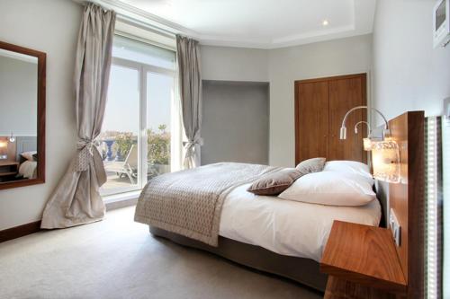 a bedroom with a bed and a large window at Le Rhul in Marseille