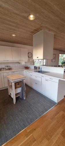 a kitchen with white cabinets and a wooden table at Holiday home close to forest, lake and skiing in Ulricehamn