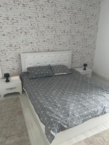 a bed in a room with a brick wall at Garsoniera Mtk in Turnu Măgurele