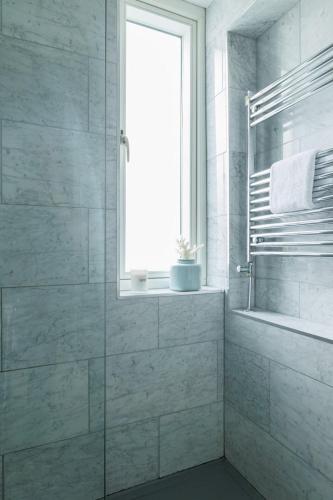 a bathroom with a shower and a window at GuestReady - Contemporary home with garden in Dublin