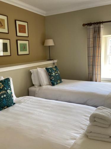 une chambre avec deux lits et une fenêtre dans l'établissement Fordie West Cottage, à Comrie