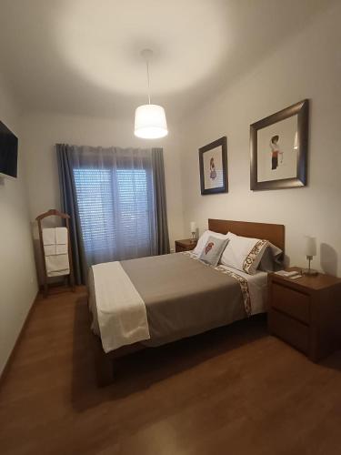 a bedroom with a bed and a window at Portela - APARTAMENTO in Viana do Castelo