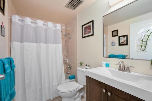 Un baño con un inodoro blanco y un lavabo. en Kona Plaza#414, en Kailua-Kona
