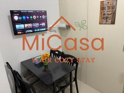 a sign on a wall with a table with chairs at MiCasa South Residences Cozy & Affordable Stay in Manila