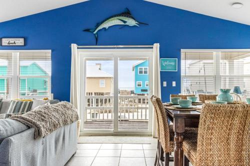 een eetkamer met een blauwe muur met een vis aan de muur bij Bikini Bottom in Gulf Shores