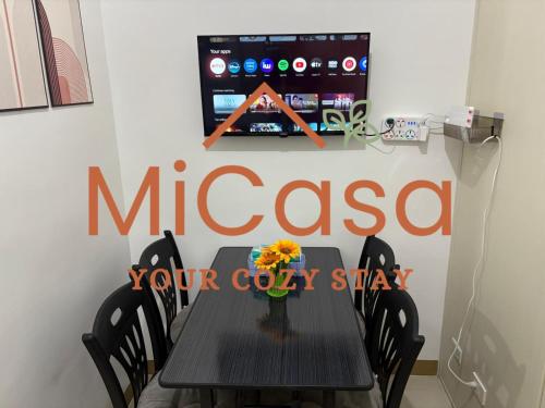 a black table with a vase of flowers on it at MiCasa South Residences Cozy & Affordable Stay in Manila