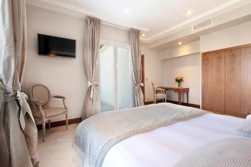 a bedroom with a bed and a tv on the wall at Le Rhul in Marseille