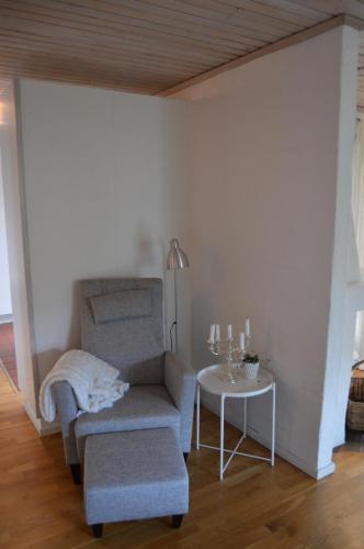 a living room with a chair and a table at Holiday home close to forest, lake and skiing in Ulricehamn