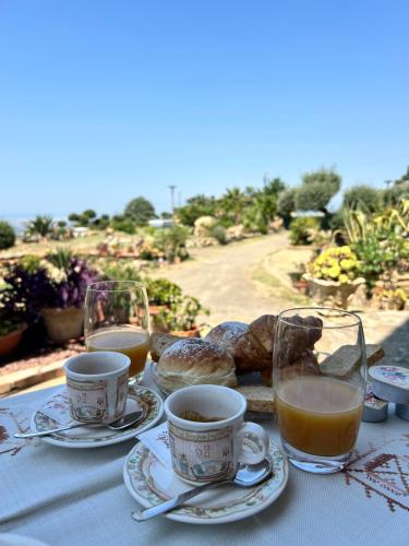 a table with cups and plates of food and drinks at B&B Quota 424 in Altavilla Silentina