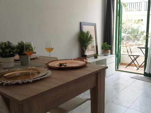 a wooden table with a glass of wine on it at Mar Airport-Park by Babiniliving in Costa de Antigua