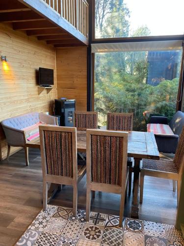 a dining room with a wooden table and chairs at Lofts Magnolias in Puerto Varas