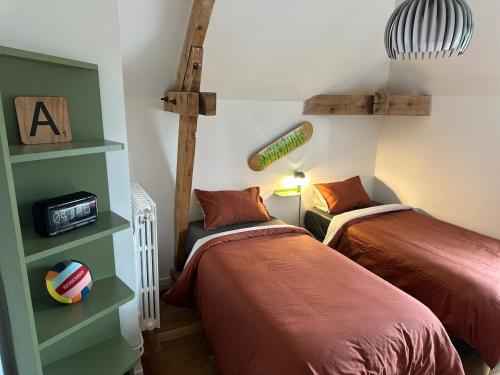 a bedroom with two beds and a baseballophone at Le Cocon de Vlinette in Brienne-le-Château