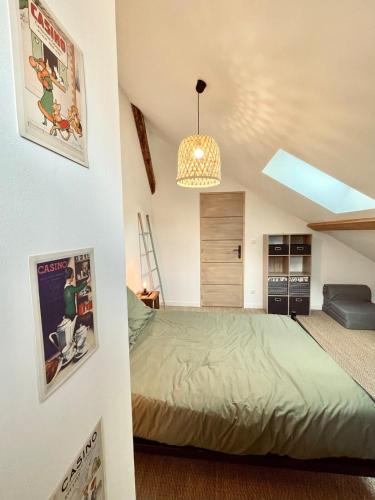 a bedroom with a bed and a chandelier at La Petite Maison in Villargondran