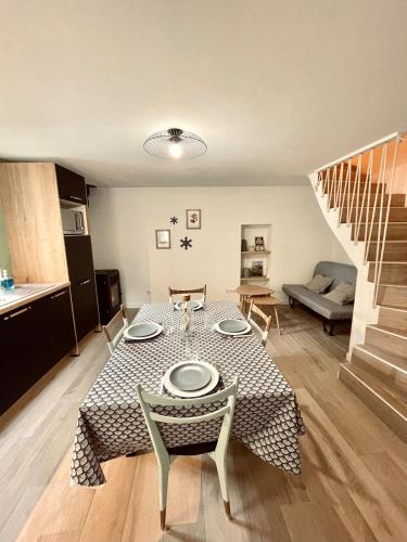 un salon avec une table et des chaises et un escalier dans l'établissement La Petite Maison, à Villargondran