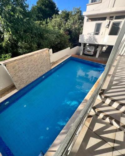 une grande piscine bleue devant une maison dans l'établissement Evlogia, à Flic-en-Flac