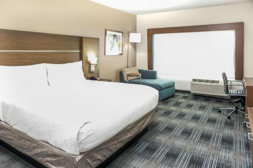 a hotel room with a bed and a chair at Holiday Inn Express & Suites - Houston Westchase - Westheimer by IHG in Houston