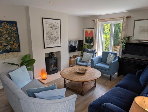 a living room with blue furniture and a table at Lewes Heights is a spacious modern luxury home with stunning views in Lewes