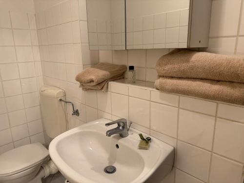 a bathroom with a sink and a toilet and towels at Modern City Apartment for 2 in Vienna