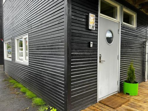 a black house with a white door and a window at Studioleilighet i Tromsø in Tromsø