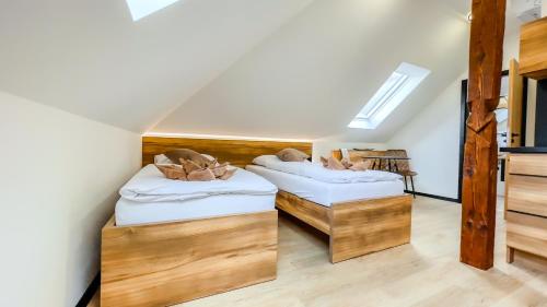 two beds in a room with wooden floors at apartmány Svätého Martina in Holíč