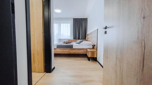 a hallway leading to a bedroom with a bed at apartmány Svätého Martina in Holíč
