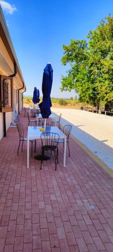 a group of tables and chairs with umbrellas on them at Agriturismoteo in Bernalda