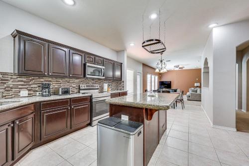 a kitchen with wooden cabinets and a large island at Private Theater and Pool Spacious Mission Home in Mission
