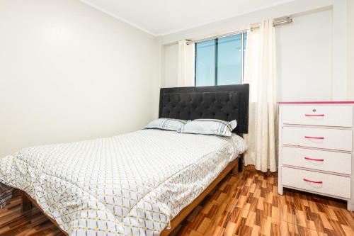 a bedroom with a bed and a dresser and a window at Alameda Suite Ayacucho in Ayacucho