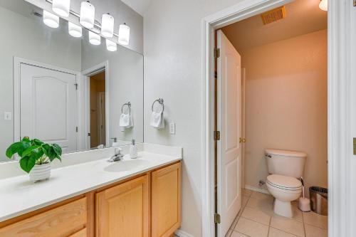 a bathroom with a sink and a toilet and a mirror at Private Theater and Pool Spacious Mission Home in Mission