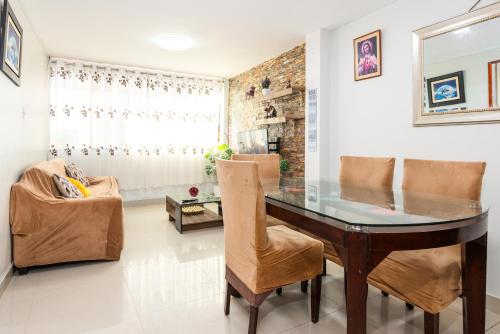 a dining room with a glass table and chairs at Alameda Suite Ayacucho in Ayacucho