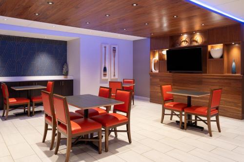 a restaurant with tables and chairs and a flat screen tv at Holiday Inn Express Sheboygan-Kohler / I-43 by IHG in Sheboygan