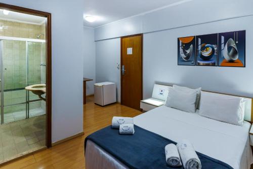 a bedroom with a large bed and a bathroom at Carillon Plaza Hotel in Sao Paulo