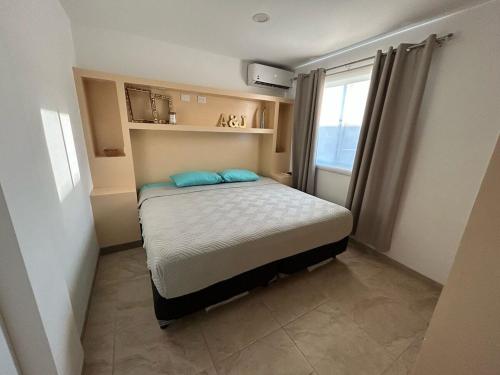 a small bedroom with a bed and a window at Tulipanes Pool AC WiFi in Cedro