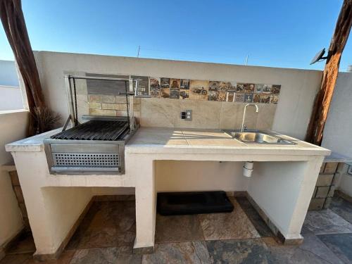 a kitchen counter with a grill and a sink at Tulipanes Pool AC WiFi in Cedro