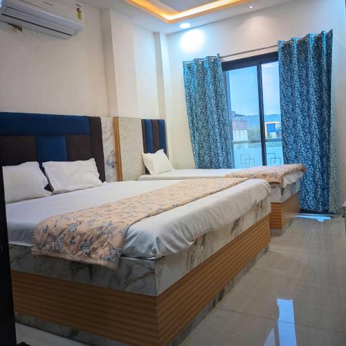 a bedroom with two beds and a large window at Hotel Moad Mudgal Palace in Godarpura