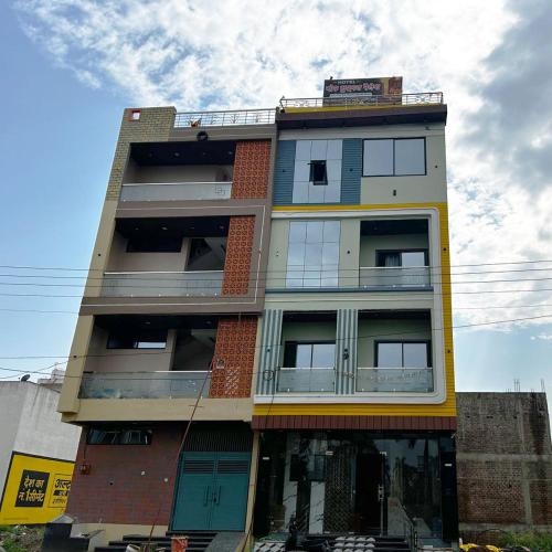 a tall apartment building with blue and yellow at Hotel Moad Mudgal Palace in Godarpura